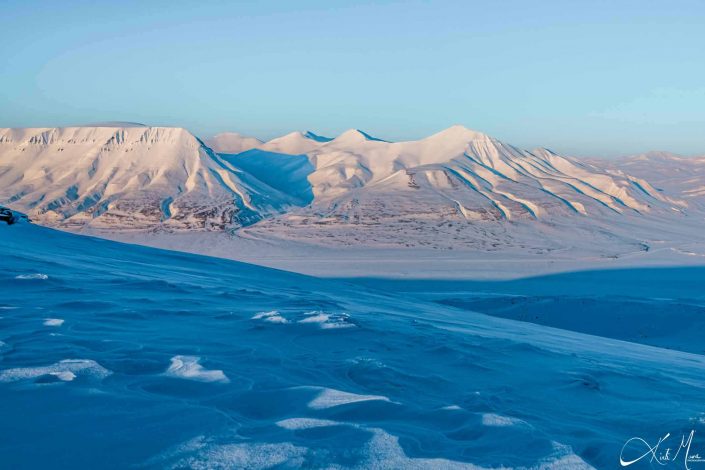 Best scenic sunset photo of snow covered mountains in Longyearbyen