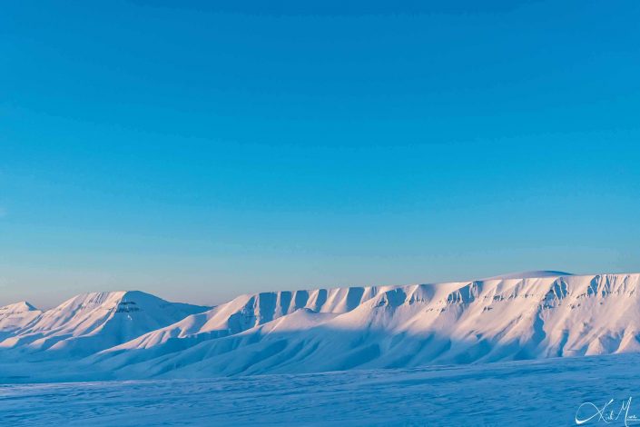 Best scenic sunset photo of snow covered mountains in Longyearbyen