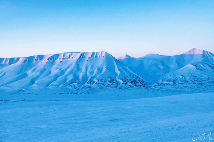 Best scenic sunset photo of snow covered mountains in Longyearbyen