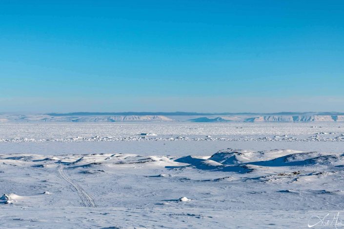 Best scenic photo of snow-covered mountains with clear blue sky and frozen sea