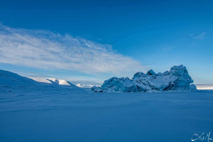 Best scenic photo of snow-covered mountains with clear blue sky and an ice berg in frozen sea