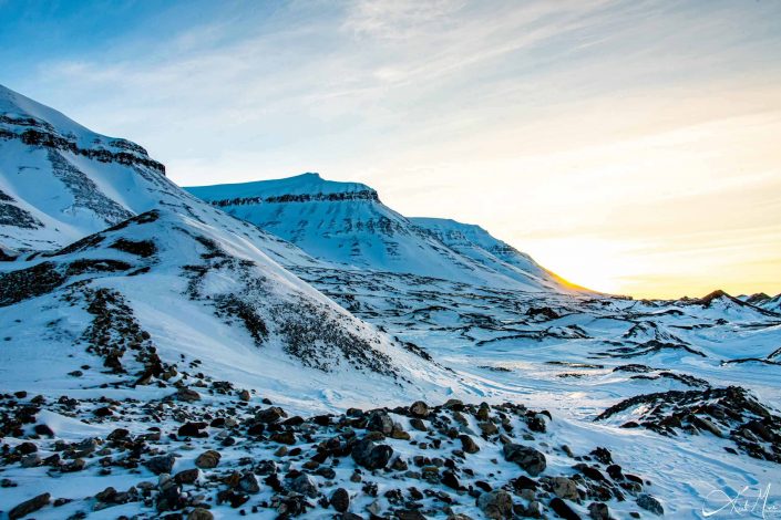 Scenic photo of snow covered mountains with sun light filtering in