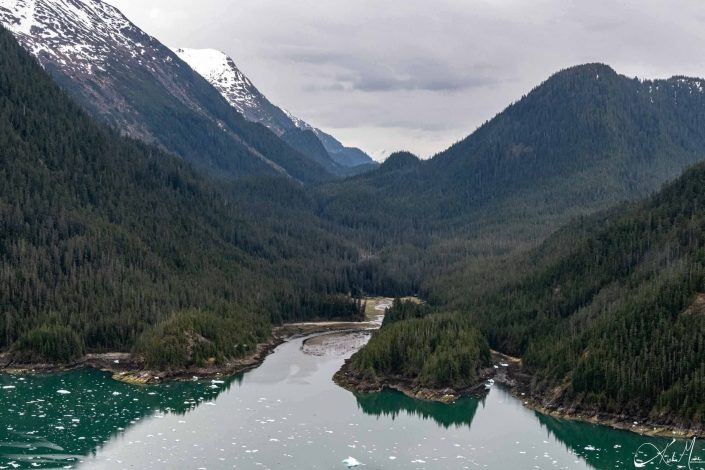 Scenic photo of mountains with green/ emerald waters in the front