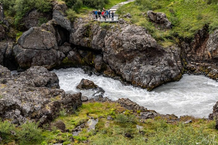 Great photo of people watching from a platform, a waterfall stream flowing