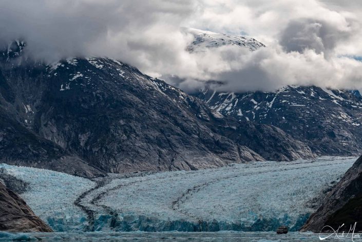 An glacier along with a ship at its base