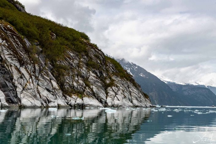 Scenic photo of Green-grey-off white mountains with its reflection in the water