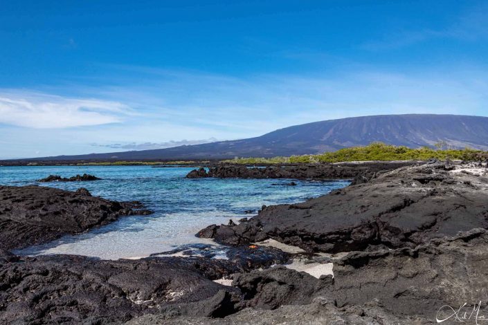 Rocky beach with turquoise waters and mountain in the background