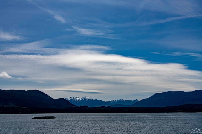 Beautiful shades of blue in the sky and the water below, with silhouette of the mountains in the middle